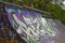 Skate ramp covered in Graffiti Art with trees in background
