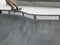 Skateboarder Grinding a Rail on the Edge of a Bowl Pool at a Skate Park