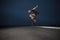 Skateboarder performing a ollie flip on a concrete pavement