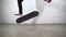 Skateboarder performing skateboard trick - heel flip on concrete. Athlete practicing jump on white background, preparing for