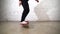 Skateboarder performing skateboard trick - kick flip on concrete. Athlete practicing jump on white background, preparing for