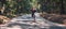 Skateboarder ride a longboard through the forest â€“ panorama