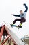 A skateboarder teenager in a hat does a trick with a jump on the ramp. A skateboarder is flying in the air