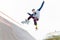 A skateboarder teenager in a hat does a trick with a jump on the ramp. A skateboarder is flying in the air