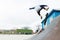 A skateboarder teenager in a hat does a trick with a jump on the ramp. A skateboarder is flying in the air