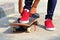 Skateboarder tying shoelace at skate park