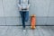 Skateboarder using smartphone leaning on wall in city