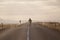 Skater on empty road with maks in Iceland. Great light in the ba