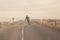 Skater on empty road with maks in Iceland. Great light in the ba