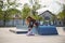 Skater female putting on protective clothing before a ride in a skatepark. Cool tattooed roller blader prepares for skating in a