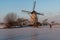 Skater on the frozen canal along the windmills alignment