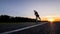 Skater make pushing on empty road at the beautiful sunset