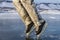 A skater man in black skates in winter warm ski pants shows a moon walk on the clear blue ice of the sacred Lake Baikal in winter.