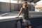 Skater Man Portrait. Hipster In Casual Outfit Sitting On Concrete Ramp At Skatepark