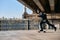 Skater rides on skateboard at empty concrete embankment on the urban background