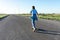 Skater Young woman from the back in blue jeans and a t-shirt skateboarding on the road in summer