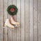 Skates hanging on the wooden planks wall with garland, winter Christmas background