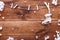 Skating on winter concept, white ice skate hanging on wooden brown background with snowflakes, top view with copy space