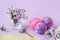 Skeins of multi - colored yarn - purple and pink ,with a bouquet of chrysanthemums and knitting needles, purple background-the