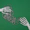 Skeleton of the hand is held by a pearl decorative ribbon on a green background