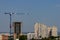 The skeleton of a new multi-storey residential building under construction next to a large multi-apartment inhabited and new build