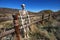 Skeleton resting on wooden pole rail fence