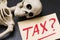 Skeleton and tag with text. The concept of large taxes for the population