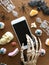 Skeleton using smartphone. Halloween decorations on wooden background