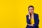 Skeptical business woman in disbelief talking on phone deciding what to answer looking to copy space isolated yellow background