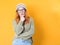 Skeptical young woman thinks while looks to side. Closeup portrait of doubtful girl with confused expression, isolated on yellow