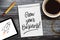 Sketchbook with written message Grow your business on a wooden desk with tablet, pencil and cup of coffee