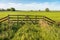 Skewed and weathered old wooden gate on the edge of a Dutch meadow