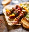 Skewers of grilled meat and vegetables on a wooden table