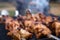 Skewers with roasted chiken meat on the hot grill closeup