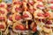 Skewers of shrimps with tomatoes, strung on wooden sticks closeup