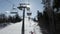 Ski chairlift with people moving up, pov view