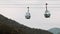 Ski elevator cable way for people transportation on summer mountain. Chairlift on the hill, gray sky. Cable car lifts