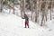 Ski girl climbing uphill in winter forest