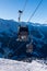 Ski gondola over blue sky and mountains on the background.