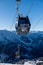 Ski gondola over blue sky and mountains on the background.