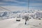 Ski lift empty ropeway on hilghland alpine mountain winter resort on bright sunny day.