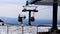 Ski lift moves on the background of the mountain and the blue spring sky