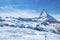 Ski lift moving over snow covered Matterhorn mountain against blue sky