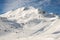 Ski lift ropeway on hilghland alpine mountain winter resort on bright sunny day. Ski chairlift cable way with people