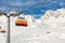 Ski lift ropeway on hilghland alpine mountain winter resort on bright sunny day. Ski chairlift cable way with people