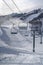 Ski lifts overlooking sunlit snow covered mountain