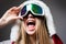 Ski mask. Sport. Extreme sport. Winter leisure. Laughing happy girl with ski mask on grey background. Snowboard glasses