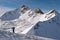 Ski mountaineer with snowy rocky mountain peak in the background.