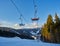 Ski resort in beautiful sunset light. View from the top: ski tracks, pine tree forest and mountains in the background