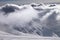 Ski slope and mountains in sunlight storm clouds before snowfall